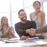 background image of the handshake of business partners in the office. business concept